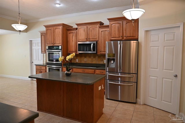 kitchen featuring hanging light fixtures, a center island, appliances with stainless steel finishes, light tile patterned floors, and backsplash