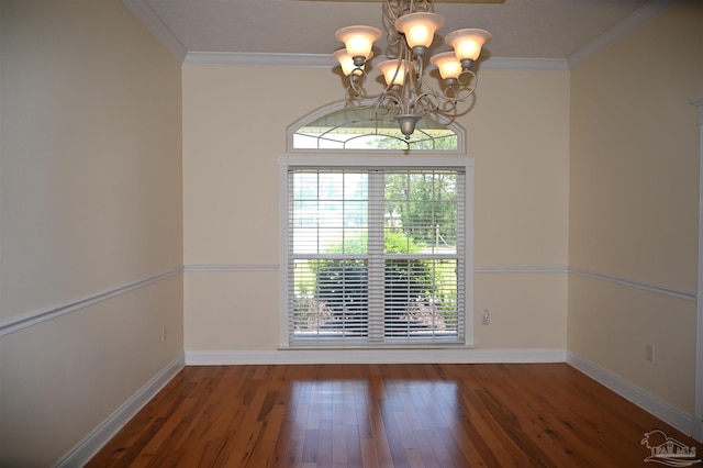 empty room with dark hardwood / wood-style floors, crown molding, and a chandelier