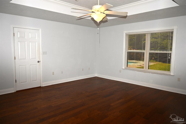 empty room with ornamental molding, ceiling fan, a raised ceiling, and hardwood / wood-style floors