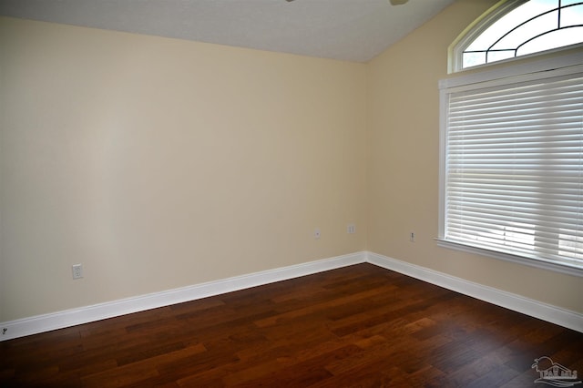 empty room featuring dark hardwood / wood-style flooring and vaulted ceiling