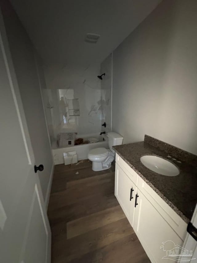 full bathroom with washtub / shower combination, vanity, toilet, and wood finished floors