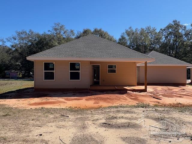 back of property with a shingled roof