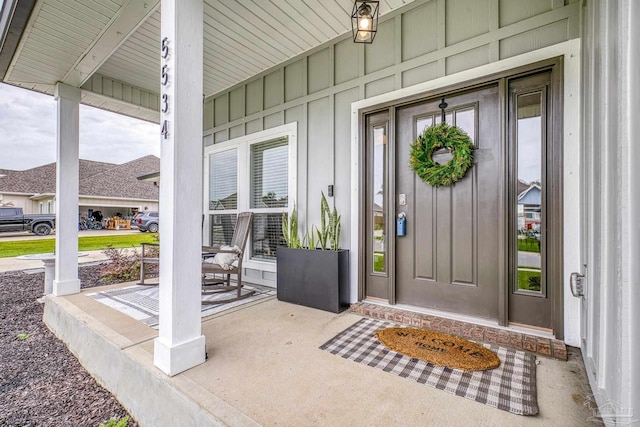 5534 Blake Ln, Pace, FL 32571 - view of exterior entry with covered porch and board and batten siding