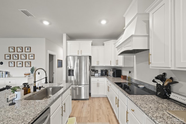 5534 Blake Ln, Pace, FL 32571 - kitchen with stainless steel fridge with ice dispenser, black electric stovetop, custom exhaust hood, a sink, and white cabinets
