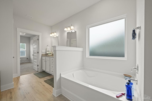 5534 Blake Ln, Pace, FL 32571 - full bathroom with wood finished floors, vanity, a bath, and baseboards