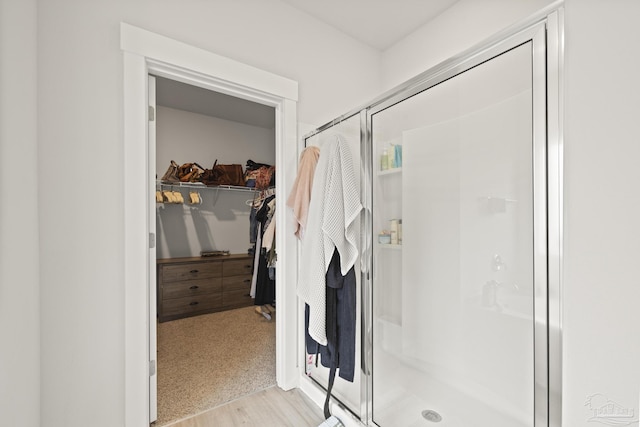 5534 Blake Ln, Pace, FL 32571 - bathroom with a stall shower, a walk in closet, and wood finished floors