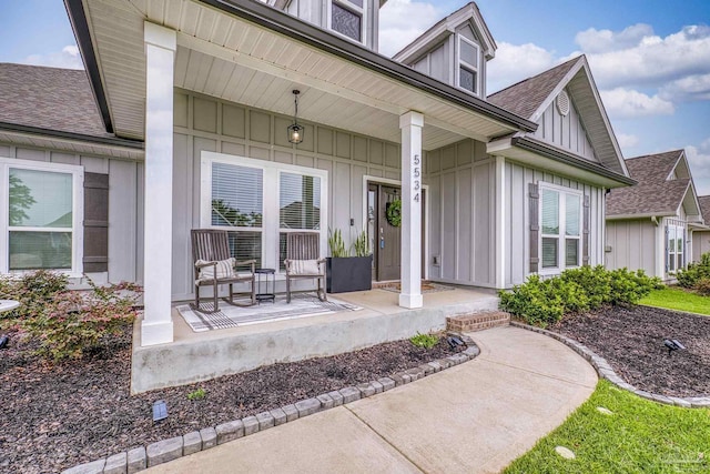 5534 Blake Ln, Pace, FL 32571 - view of exterior entry with a porch, board and batten siding, and a shingled roof