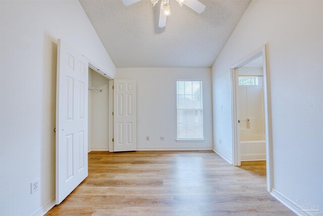 7101 Joy St Unit D5, Pensacola, FL 32504 - unfurnished bedroom featuring light wood-style flooring, a textured ceiling, ensuite bathroom, baseboards, and lofted ceiling