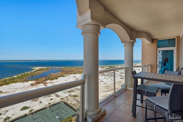 balcony with a water view and a view of the beach