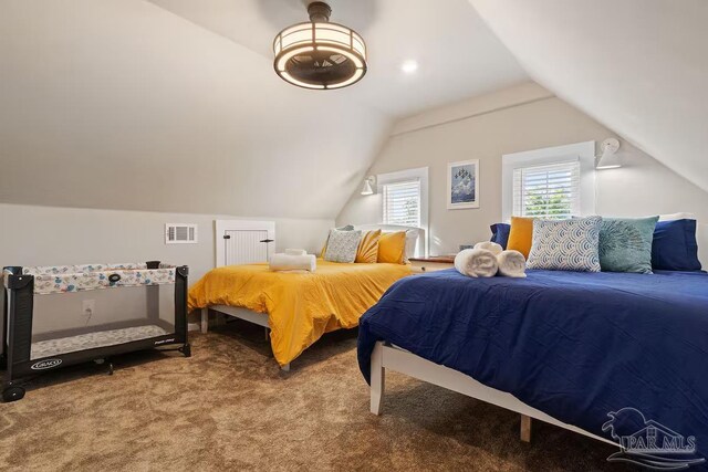 bedroom with lofted ceiling, carpet, and visible vents