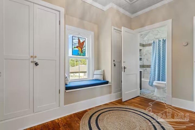 doorway to outside with wood finished floors, ornamental molding, and baseboards