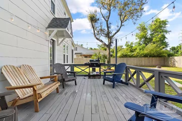 deck with a grill and fence