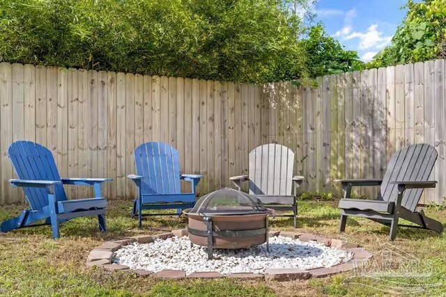view of yard with a fire pit and fence