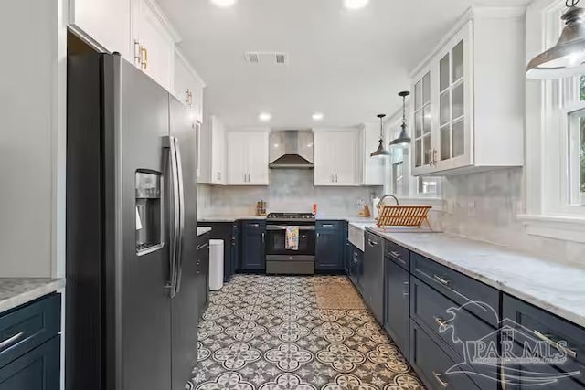 kitchen featuring white cabinetry, glass insert cabinets, appliances with stainless steel finishes, visible vents, and wall chimney exhaust hood