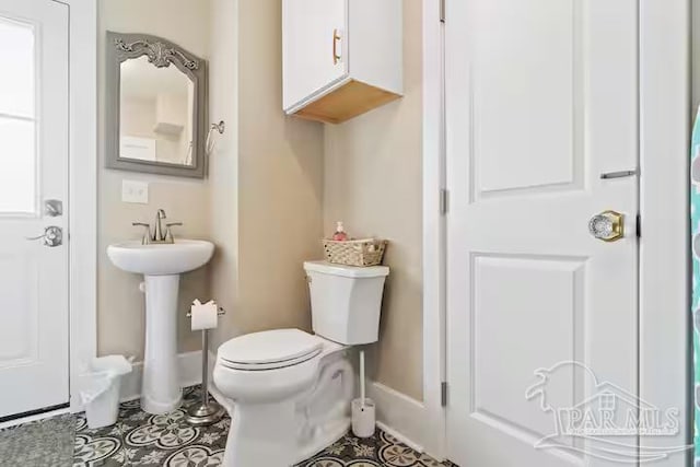 bathroom with tile patterned floors, a sink, toilet, and baseboards