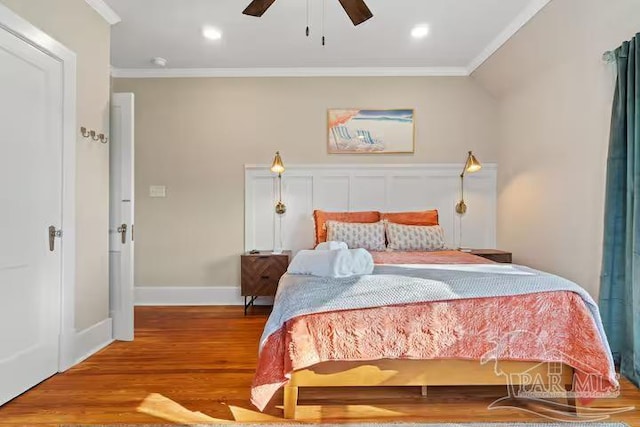 bedroom featuring wood finished floors, a ceiling fan, ornamental molding, and baseboards
