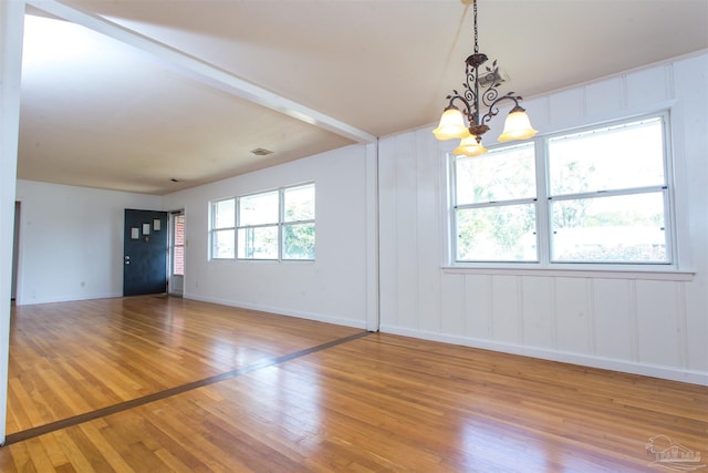 unfurnished room with baseboards, a healthy amount of sunlight, a chandelier, and light wood finished floors