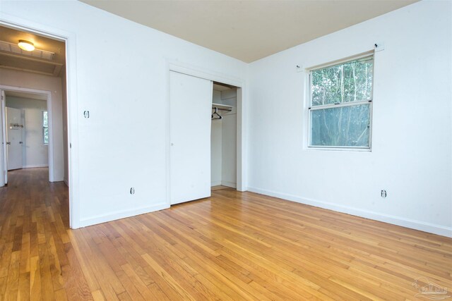 unfurnished bedroom with light wood finished floors, a closet, and baseboards