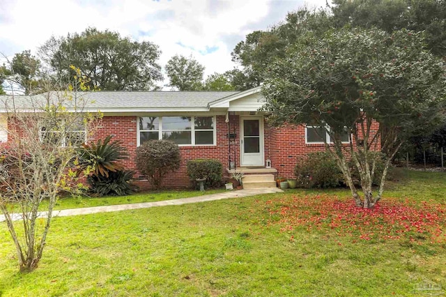 single story home featuring a front yard and brick siding