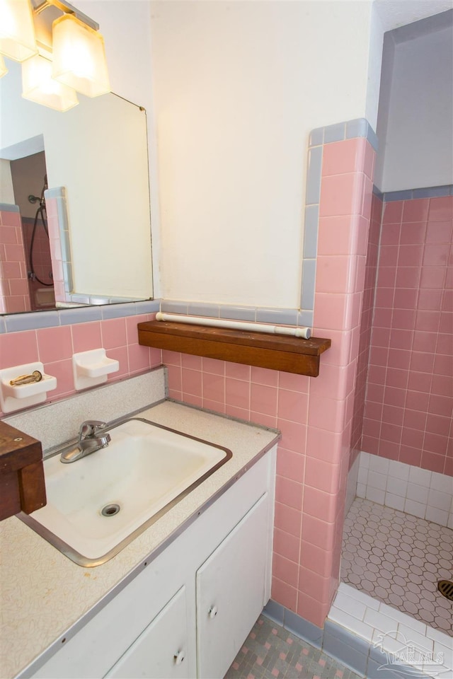 bathroom featuring vanity, tile walls, and a shower stall