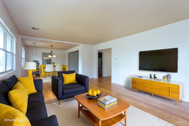 living room with a notable chandelier and light wood-type flooring