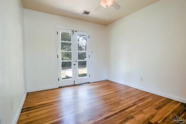 spare room featuring light wood-type flooring, visible vents, french doors, baseboards, and ceiling fan