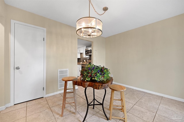 dining space with baseboards, visible vents, a notable chandelier, and light tile patterned floors