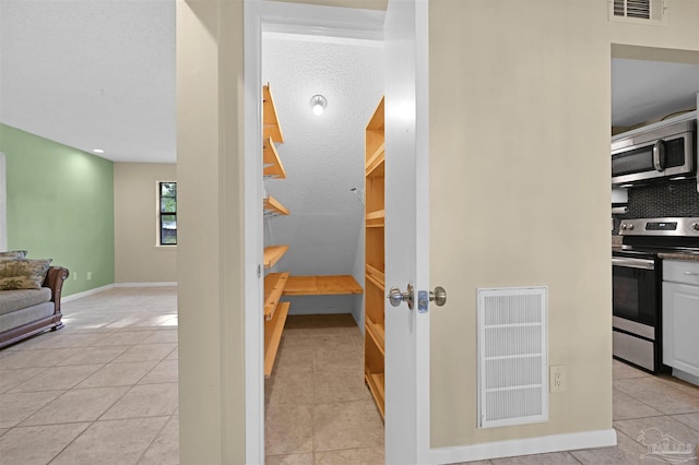 staircase featuring tile patterned floors, baseboards, and visible vents