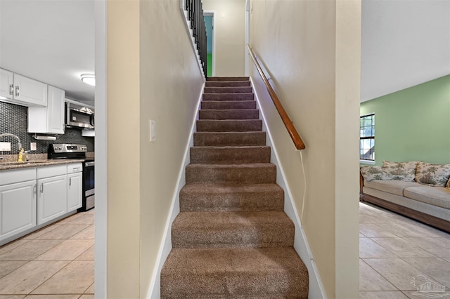 stairway with baseboards and tile patterned flooring