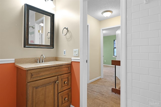 bathroom with baseboards, a textured ceiling, and vanity