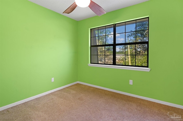 spare room featuring baseboards, a ceiling fan, and carpet flooring