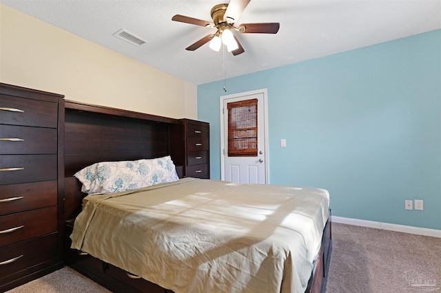 carpeted bedroom with baseboards, a ceiling fan, and visible vents