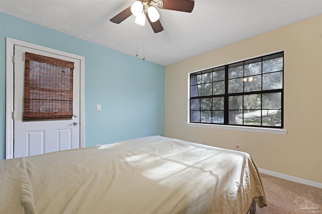 carpeted bedroom with a ceiling fan and baseboards