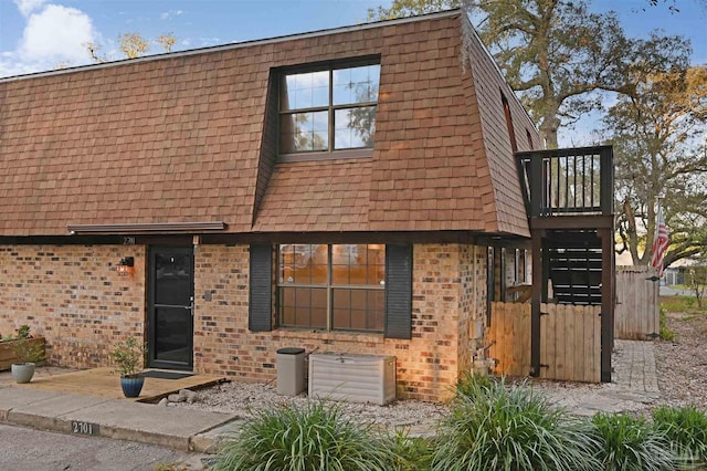 townhome / multi-family property with brick siding and mansard roof
