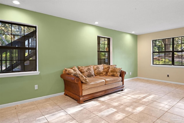 tiled living area featuring plenty of natural light, baseboards, and recessed lighting