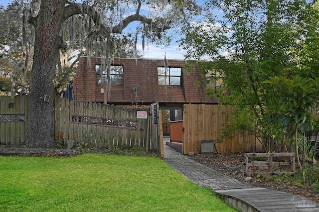 back of house featuring a lawn and fence