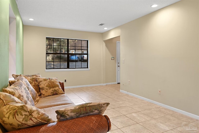 tiled living area with recessed lighting and baseboards