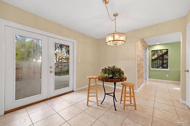 dining room with light tile patterned floors, baseboards, a barn door, and plenty of natural light