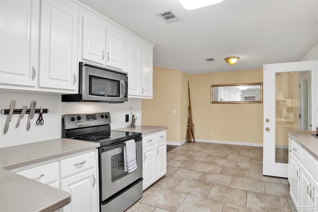 kitchen featuring appliances with stainless steel finishes, white cabinets, and light tile patterned floors