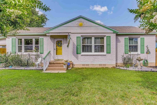 ranch-style house with crawl space, brick siding, roof with shingles, and a front yard