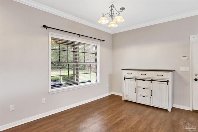 spare room featuring ornamental molding, dark hardwood / wood-style floors, and a chandelier