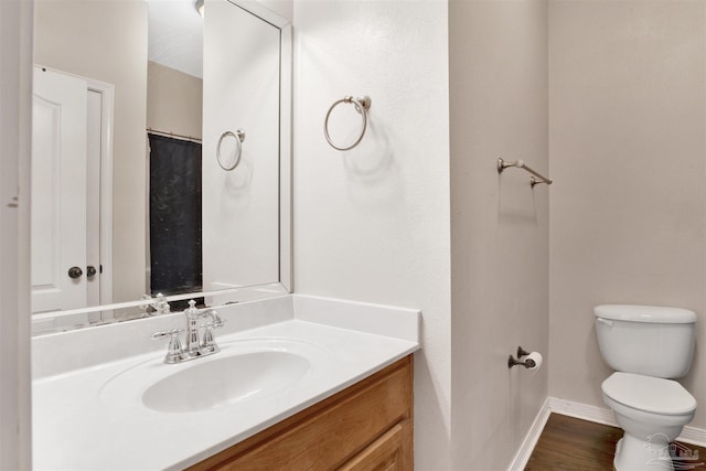 bathroom with hardwood / wood-style flooring, vanity, and toilet