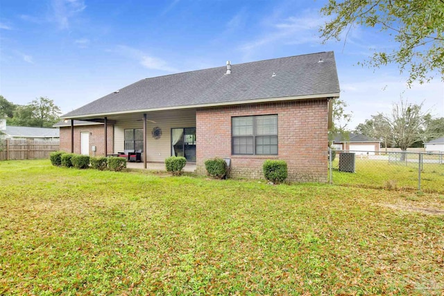 rear view of house featuring a patio, a yard, and central AC unit