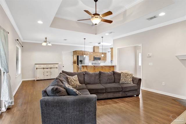 living room featuring hardwood / wood-style flooring, crown molding, ceiling fan, and a tray ceiling