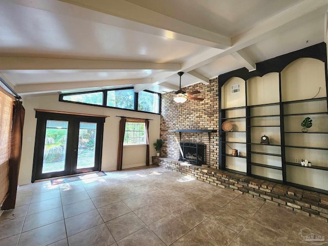 unfurnished living room featuring lofted ceiling with beams, ceiling fan, a brick fireplace, tile patterned floors, and french doors