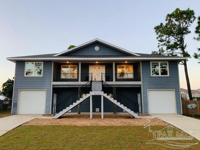 view of front of property featuring a garage, covered porch, and a yard