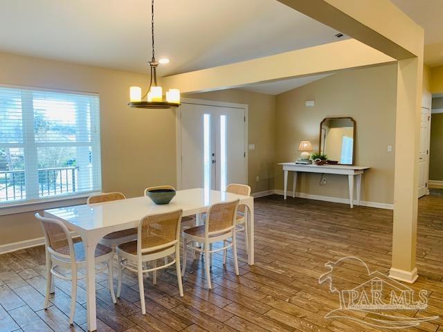 dining room with hardwood / wood-style flooring and a notable chandelier