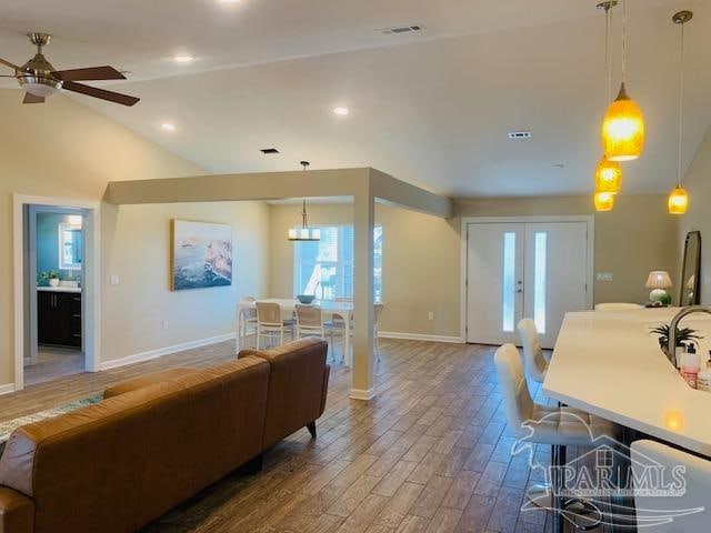 living room with french doors, wood-type flooring, high vaulted ceiling, and ceiling fan with notable chandelier