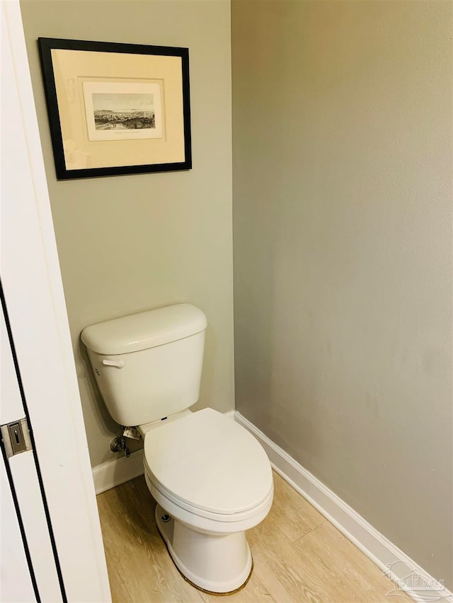 bathroom with hardwood / wood-style floors and toilet