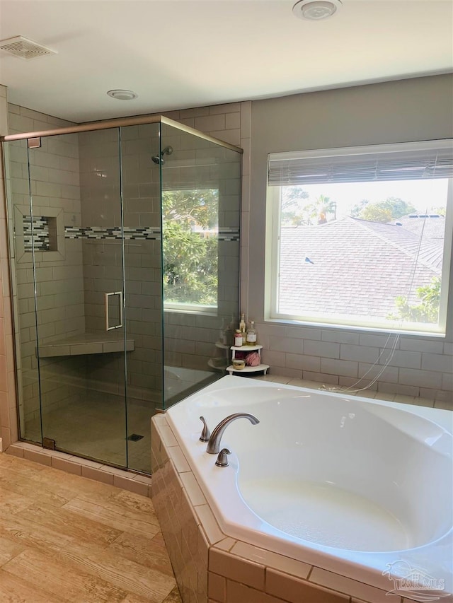 bathroom featuring hardwood / wood-style floors and shower with separate bathtub